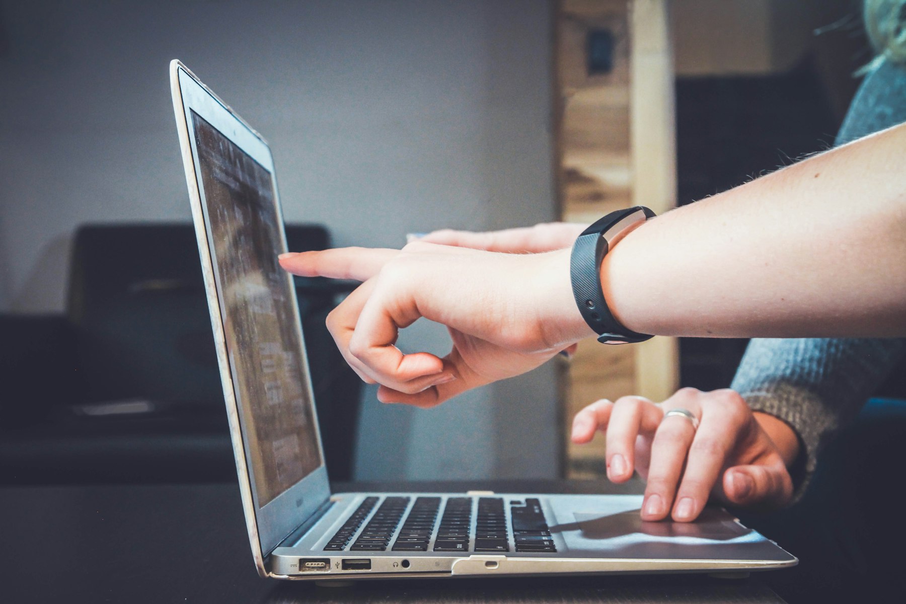 Hands working on a laptop in a dim room